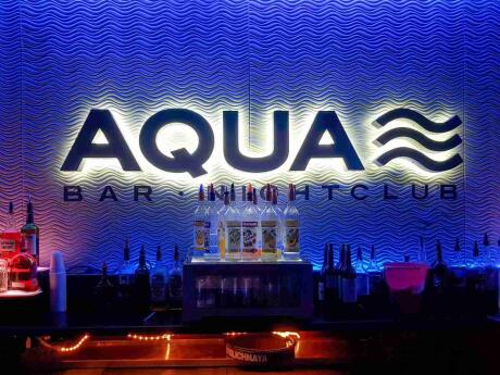 Aqua gay bar illuminated in a dark background in Key West