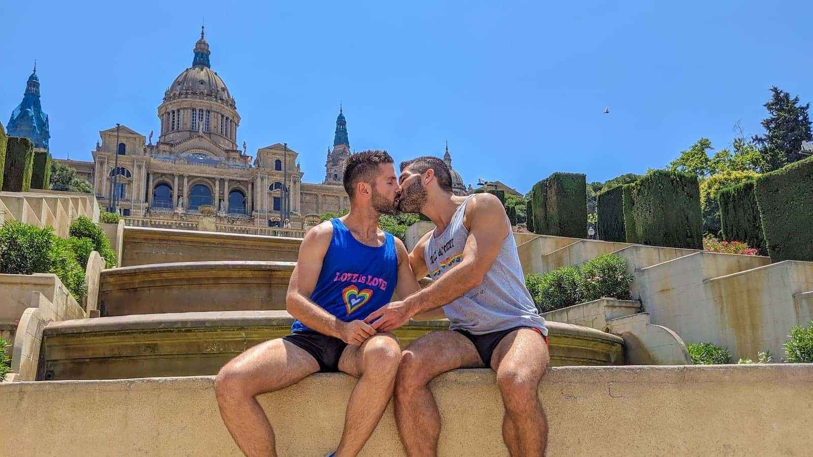 Gay couple kissing in front of the beautiful Montjuic in Barcelona.