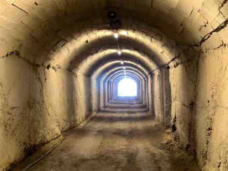 An empty underground bunker with lights stretching out of sight.