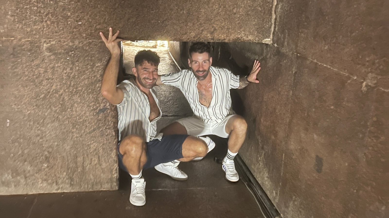 Gay couple climbing inside a pyramid in Giza, Egypt.