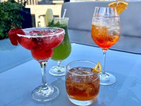 Four colorful cocktails in different sized glasses from Club on Five Lounge in Amman.