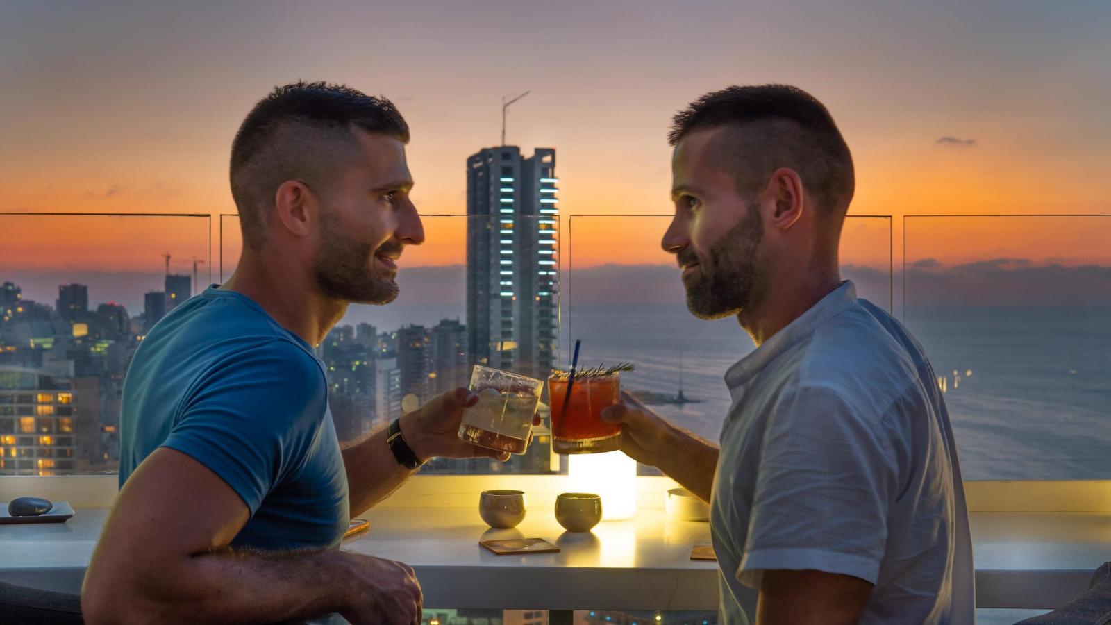 Gay couple in Beirut enjoying a cocktail at the rooftop bar of the Four Seasons Hotel