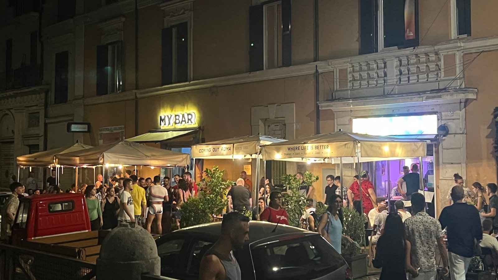 The main gay street in Rome at night, with lots of patrons spilling out onto the street from the bars.