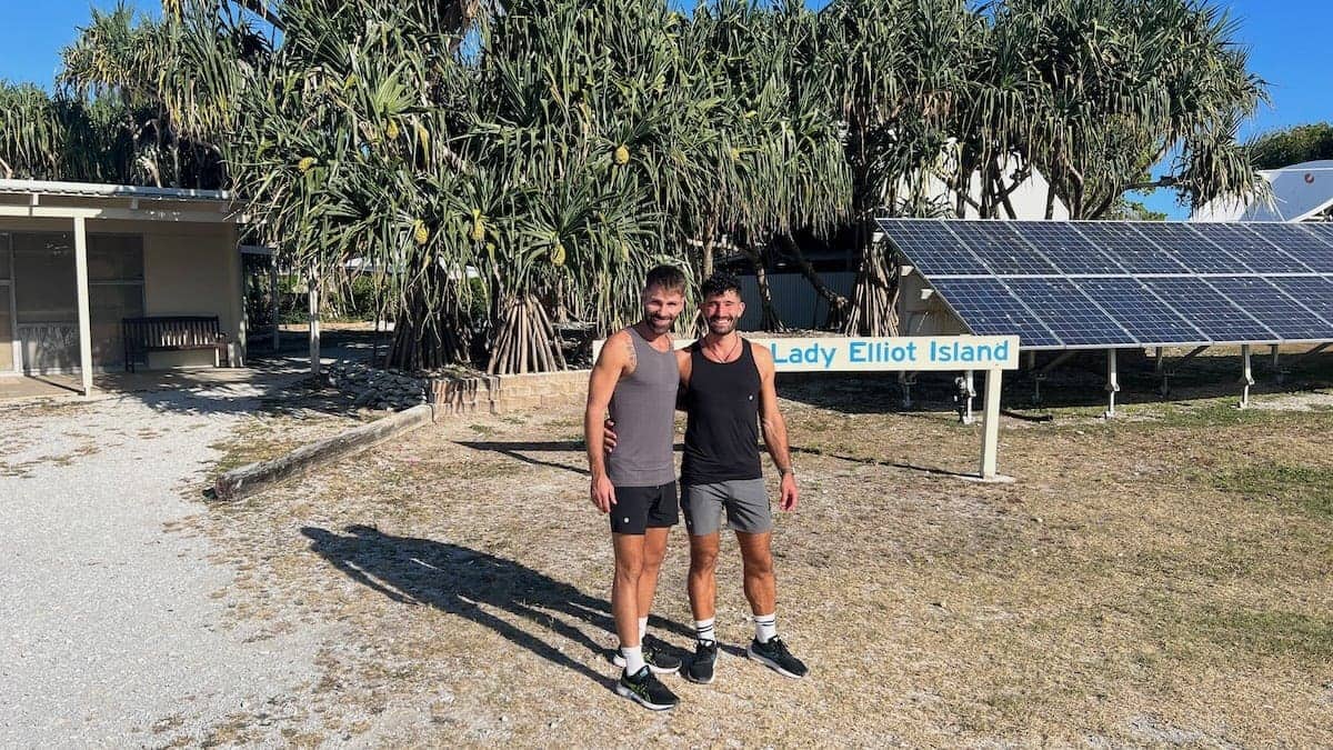 Gay couple at the Lady Elliot Island Eco Resort welcome sign.