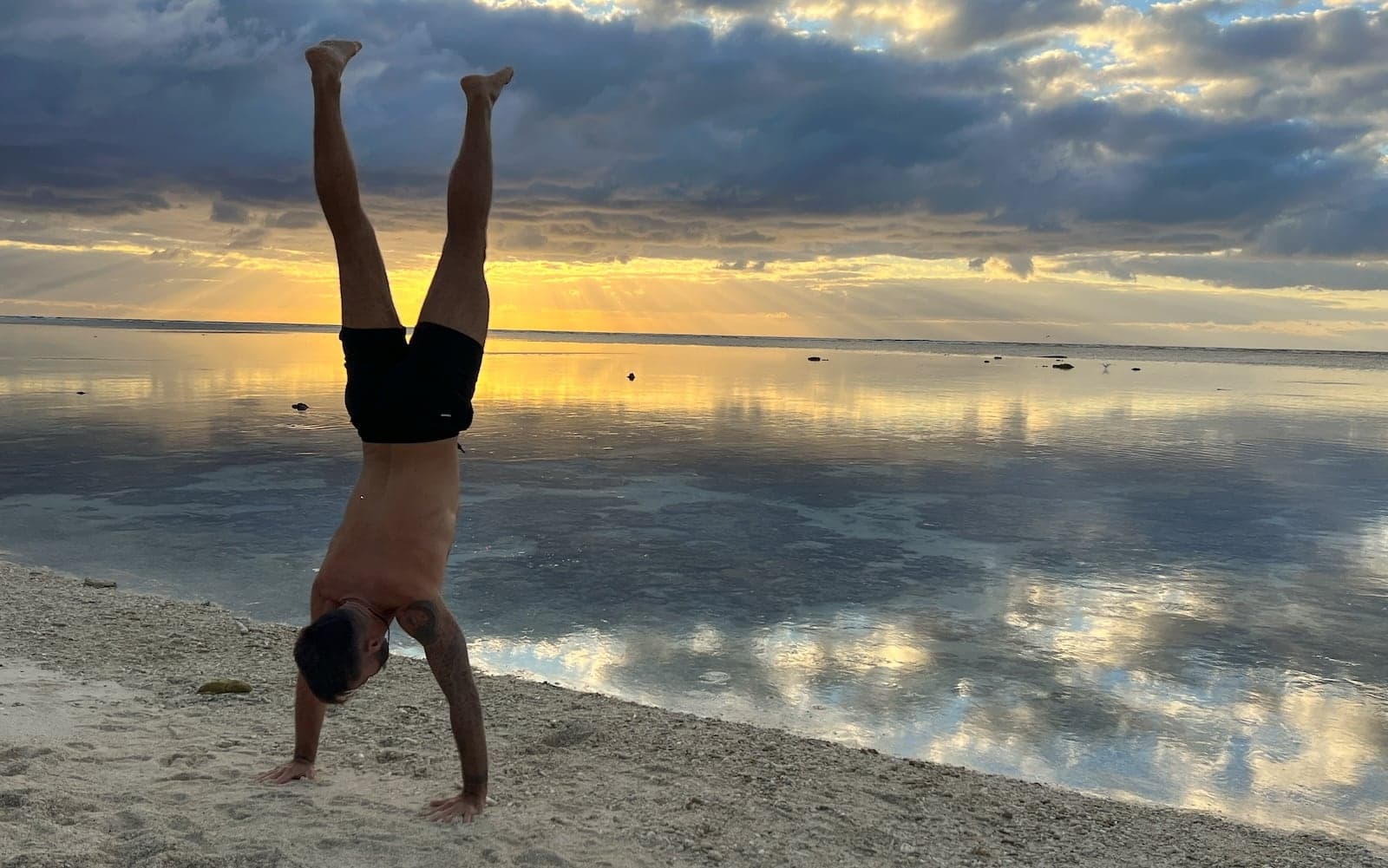 Seby doing a handstand at sunrise on Lady Elliot Island beach.