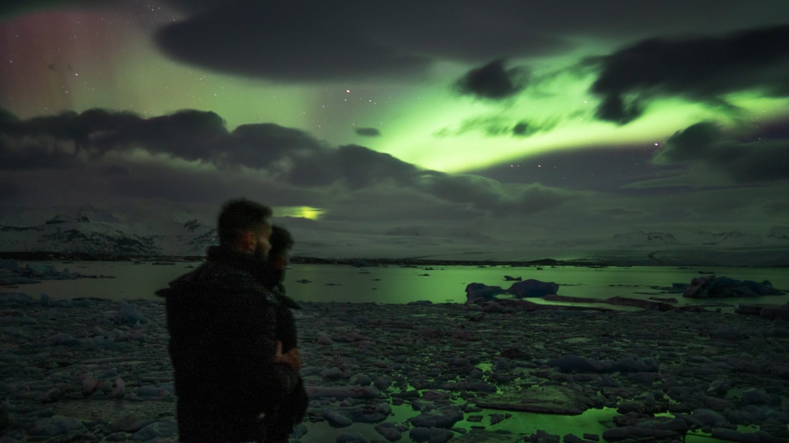 Gay couple Stef and Seby watching the Northern Lights at Diamond Beach in Iceland.