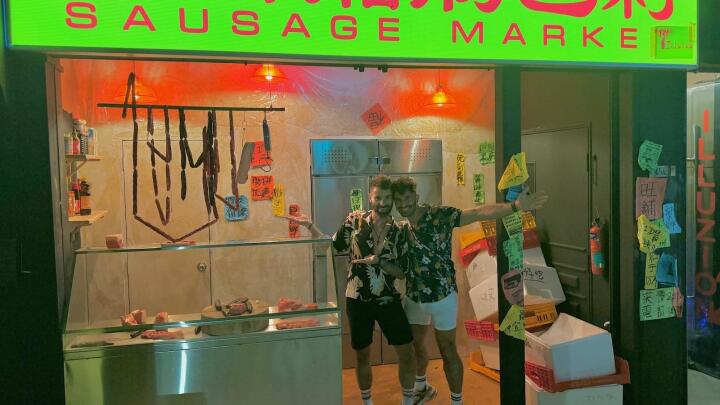 Gay couple in front of Sausage Market gay bar in Singapore.