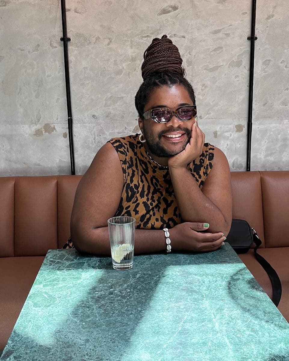 Sebo gay local from Johannesburg smiling and posing at a table in Johannesburg.