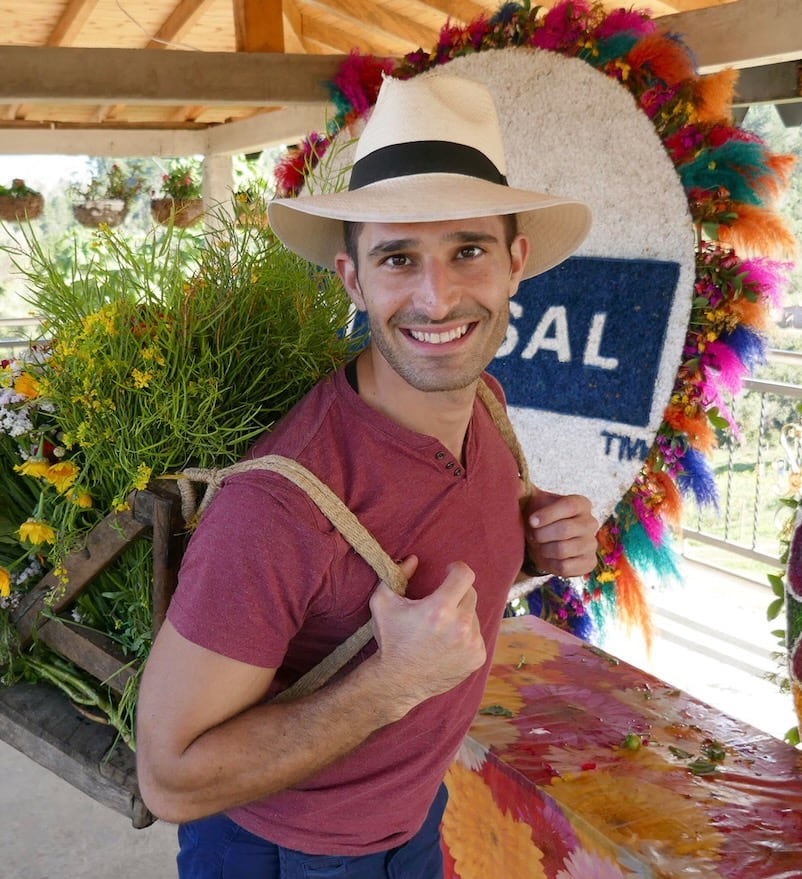 Stefan smiling holding bag of flowers.